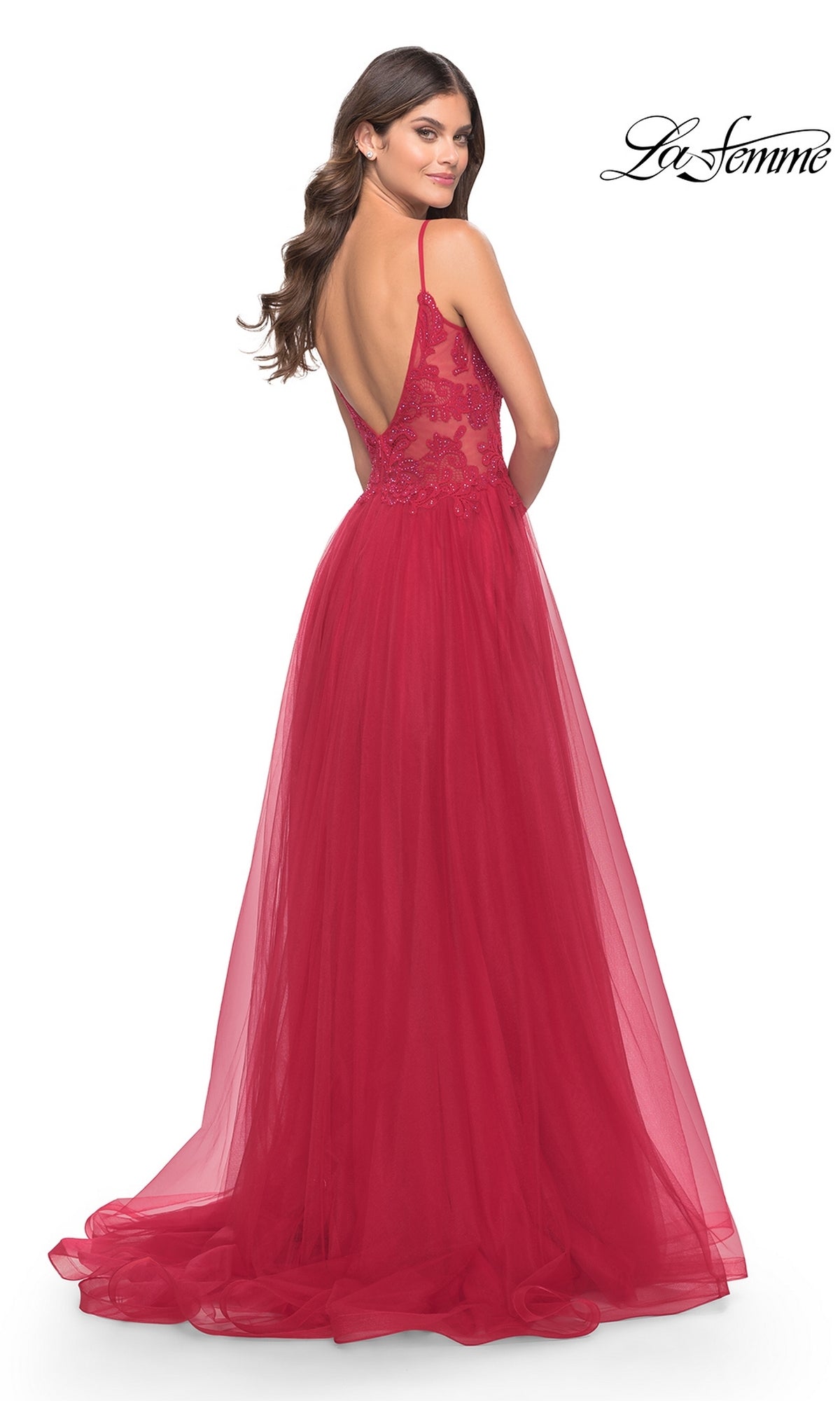 Woman in a long, red Lace-Bodice Long Tulle Prom Dress (La Femme 31507) with lace detailing, standing and looking over her shoulder.